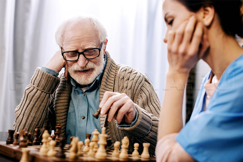 Пожилой мужчина играет в шахматы