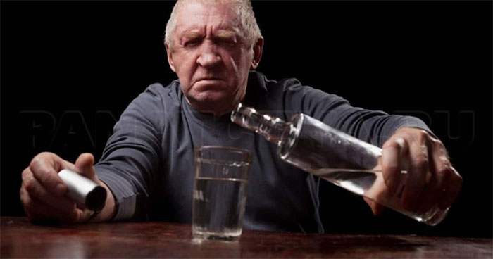 Пожилой мужчина наливает алкоголь
